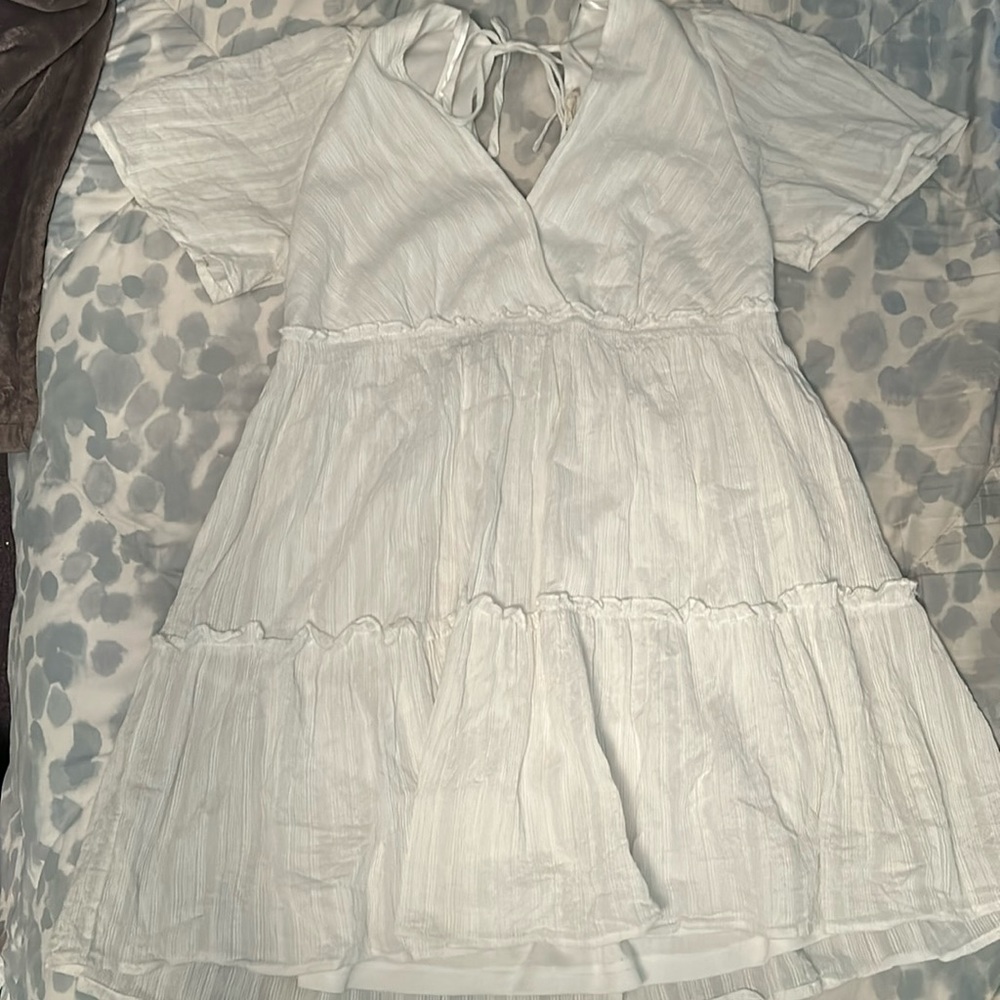 white flows dress with a tie back. long v neck style